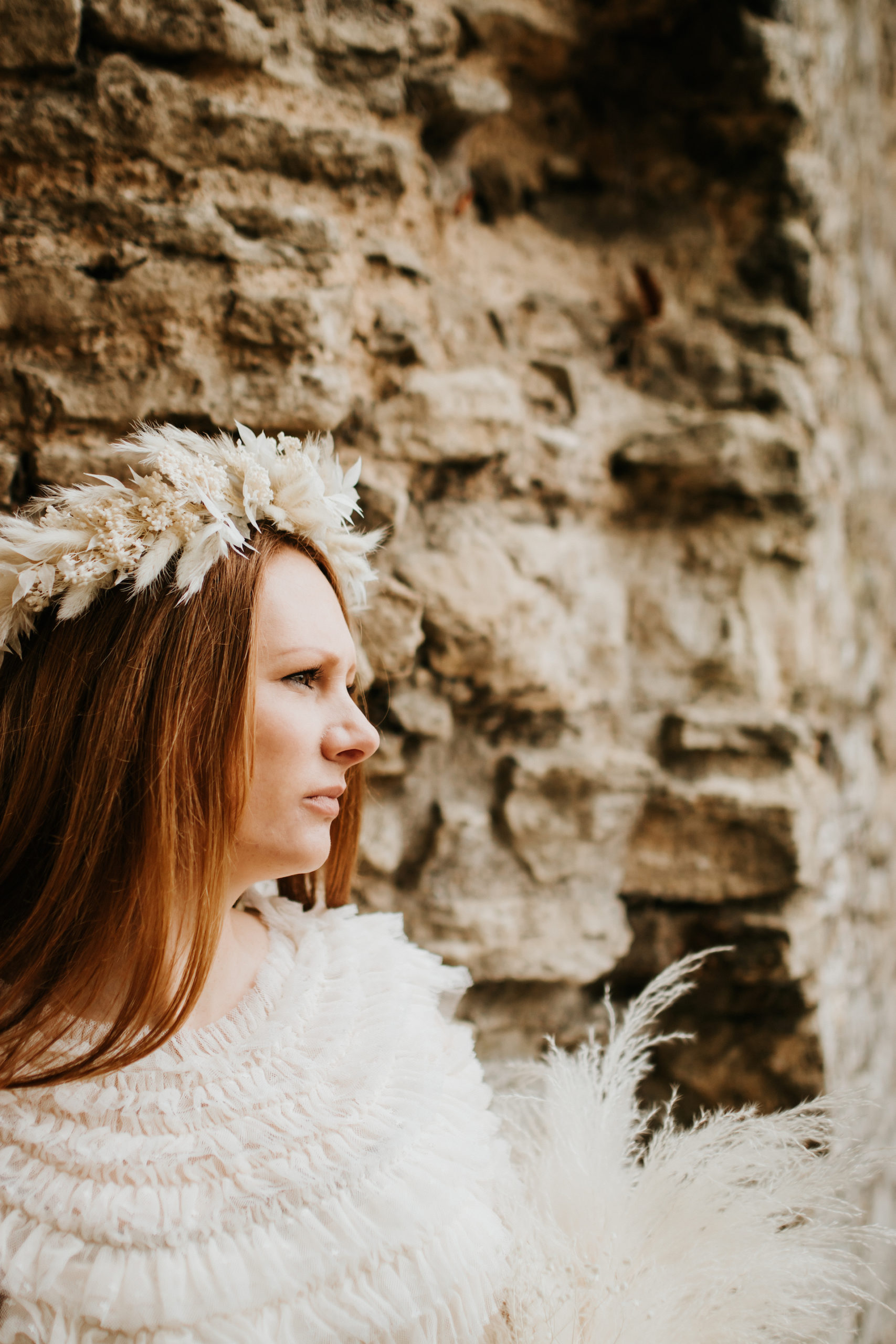 Ginger bride wearing dried flower crown and holding rustic feather bouquet | Bridal Portraits in The Cotswolds