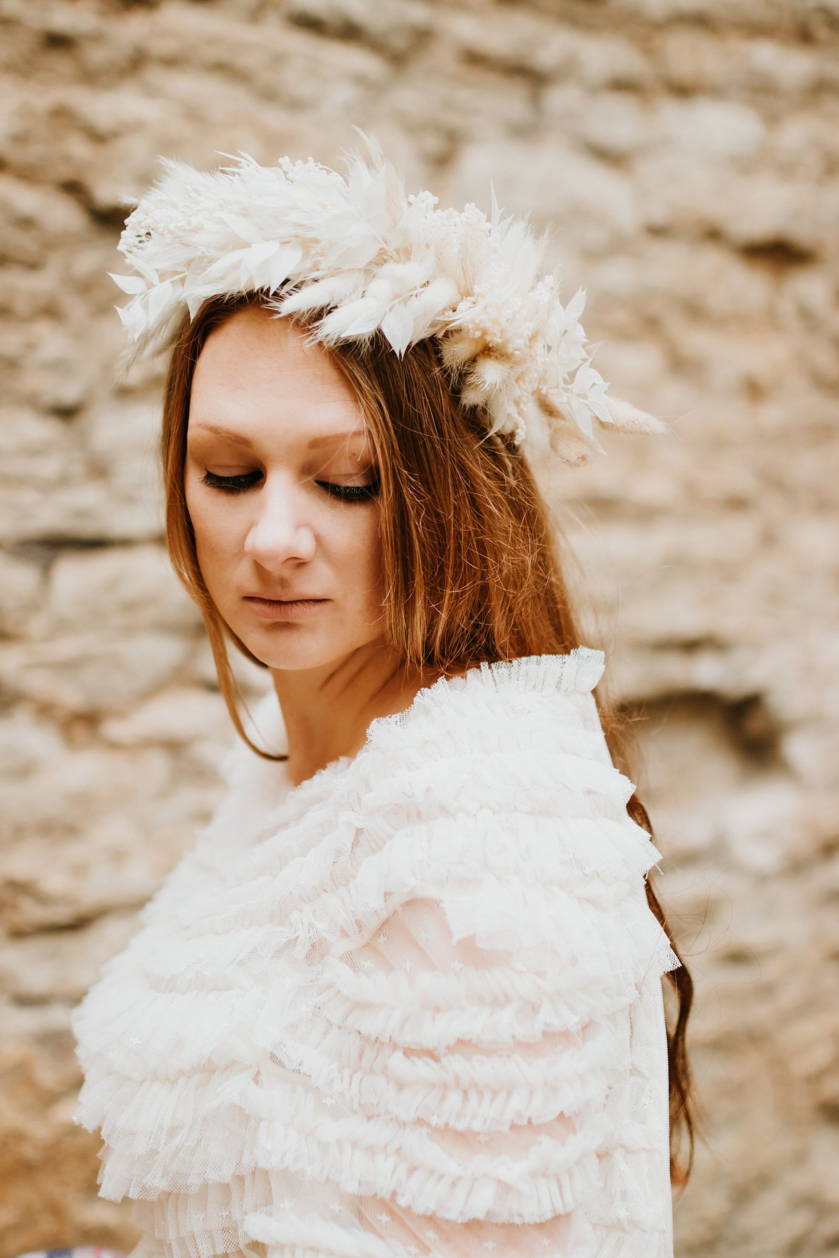 Close up of bride wearing dried floral crown and wearing a needle and thread wedding dress | Bridal Portraits in The Cotswolds