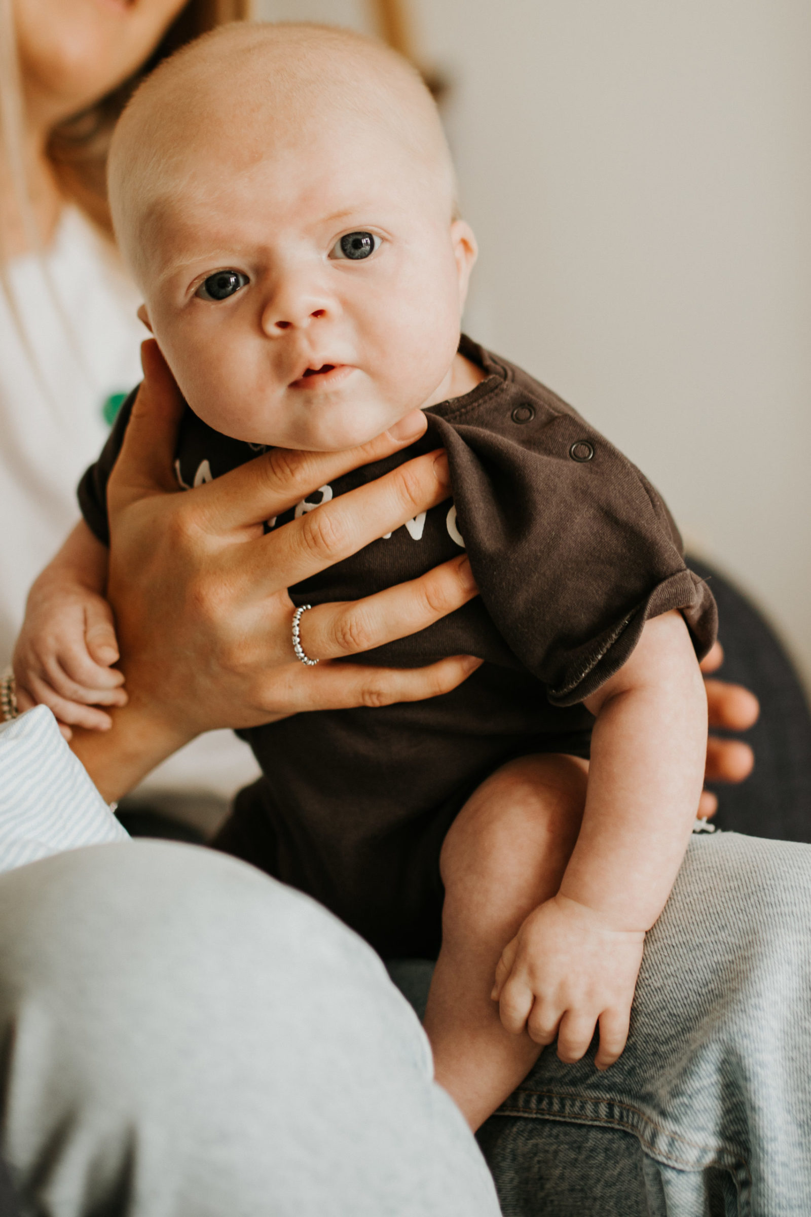Baby looking directly at camera on mothers lap
