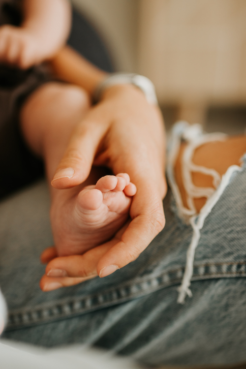 Babys foot being held by mothers hand