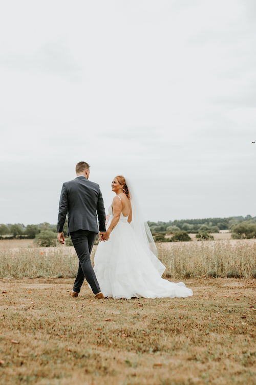 Newborn, Wedding And Family Portfolio - Bride and Groom walking in fields at Huntsmill Farm