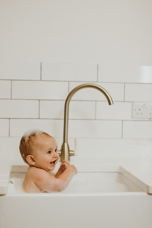 Newborn, Wedding And Family Portfolio - baby having a sink bath