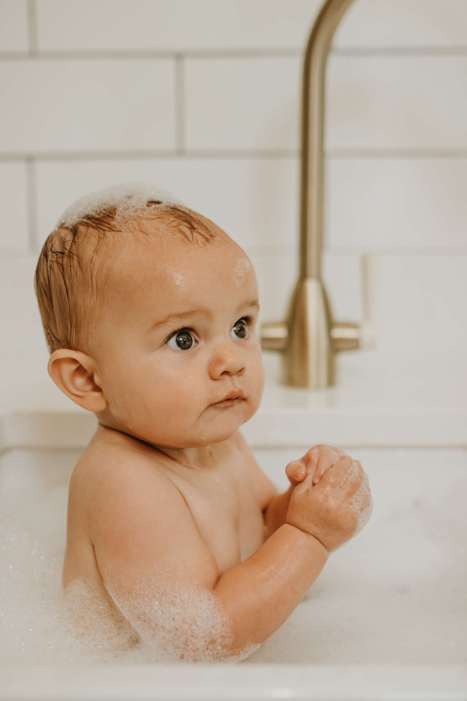 Baby having a sink bath in the kitchen | In home baby photography session