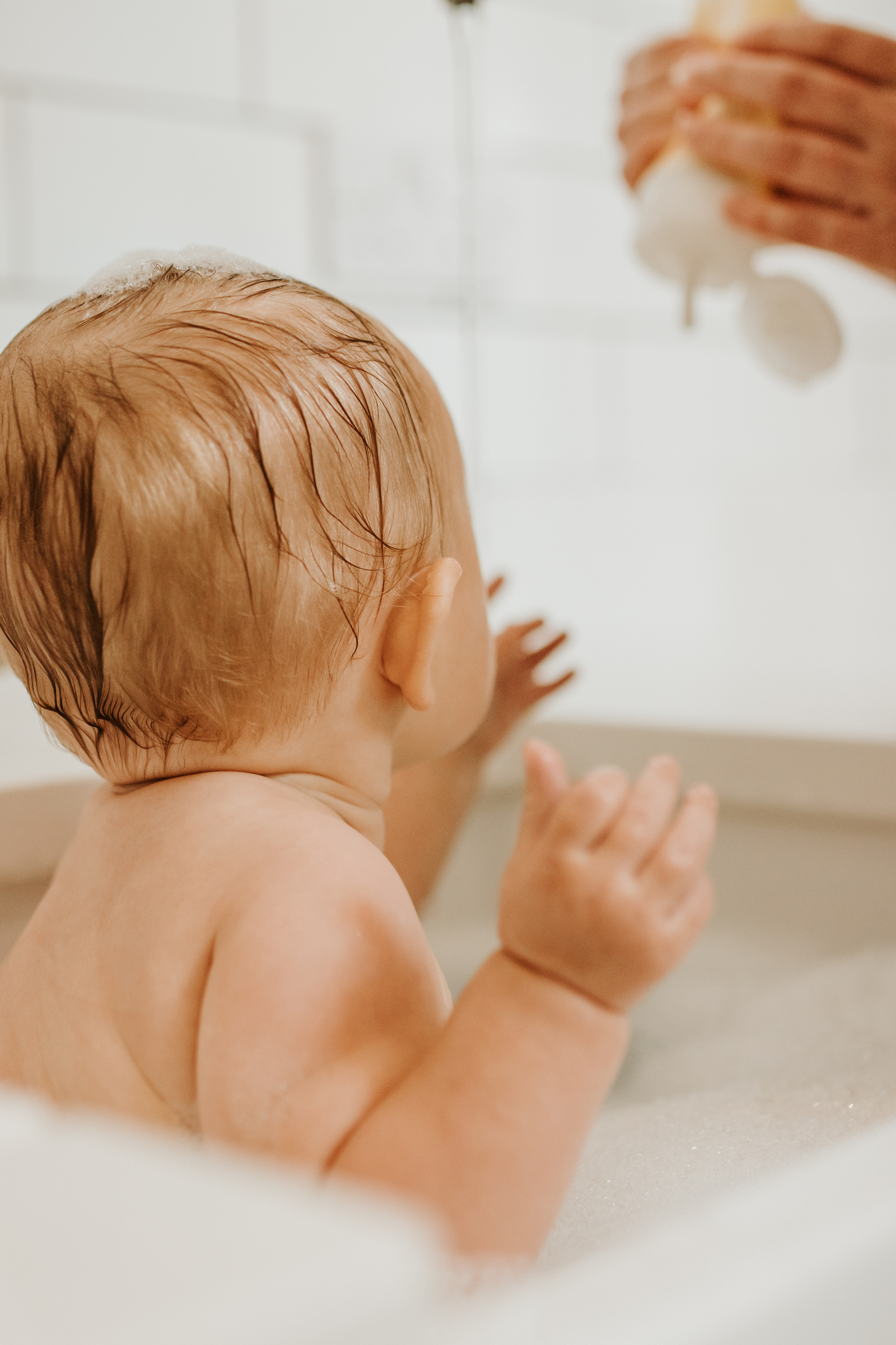 Close up of back of baby's head in the sink bath | in home baby photography session