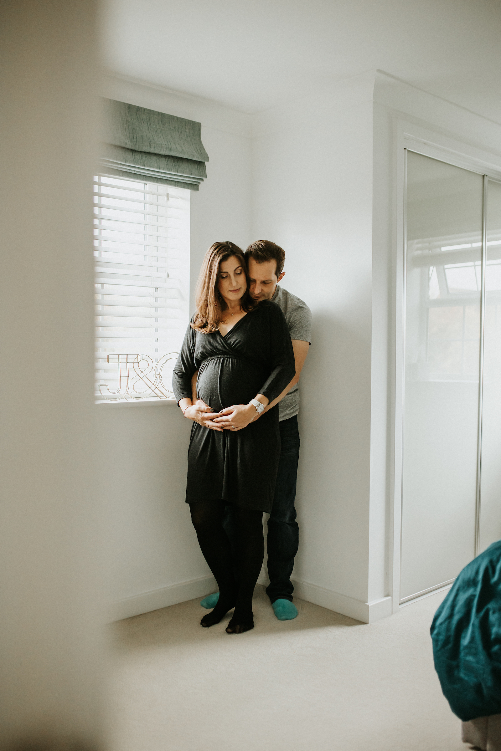 Mum and dad holding pregnancy bump during maternity photoshoot