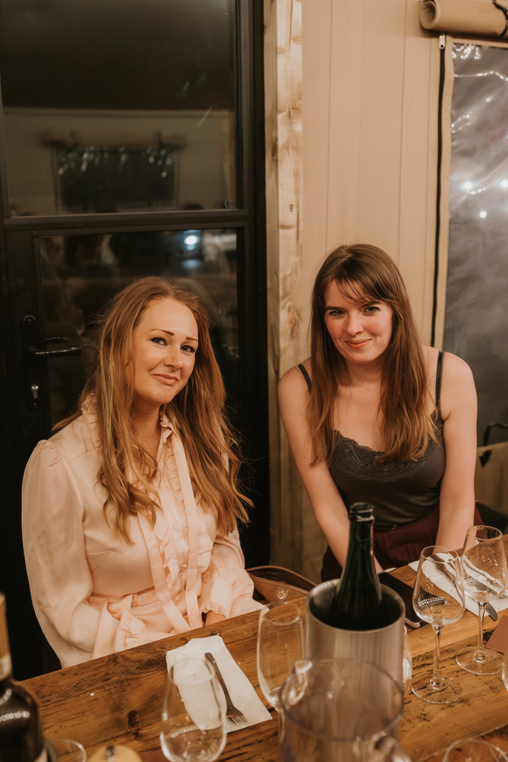 Image of two women sat having drinks together at a private event