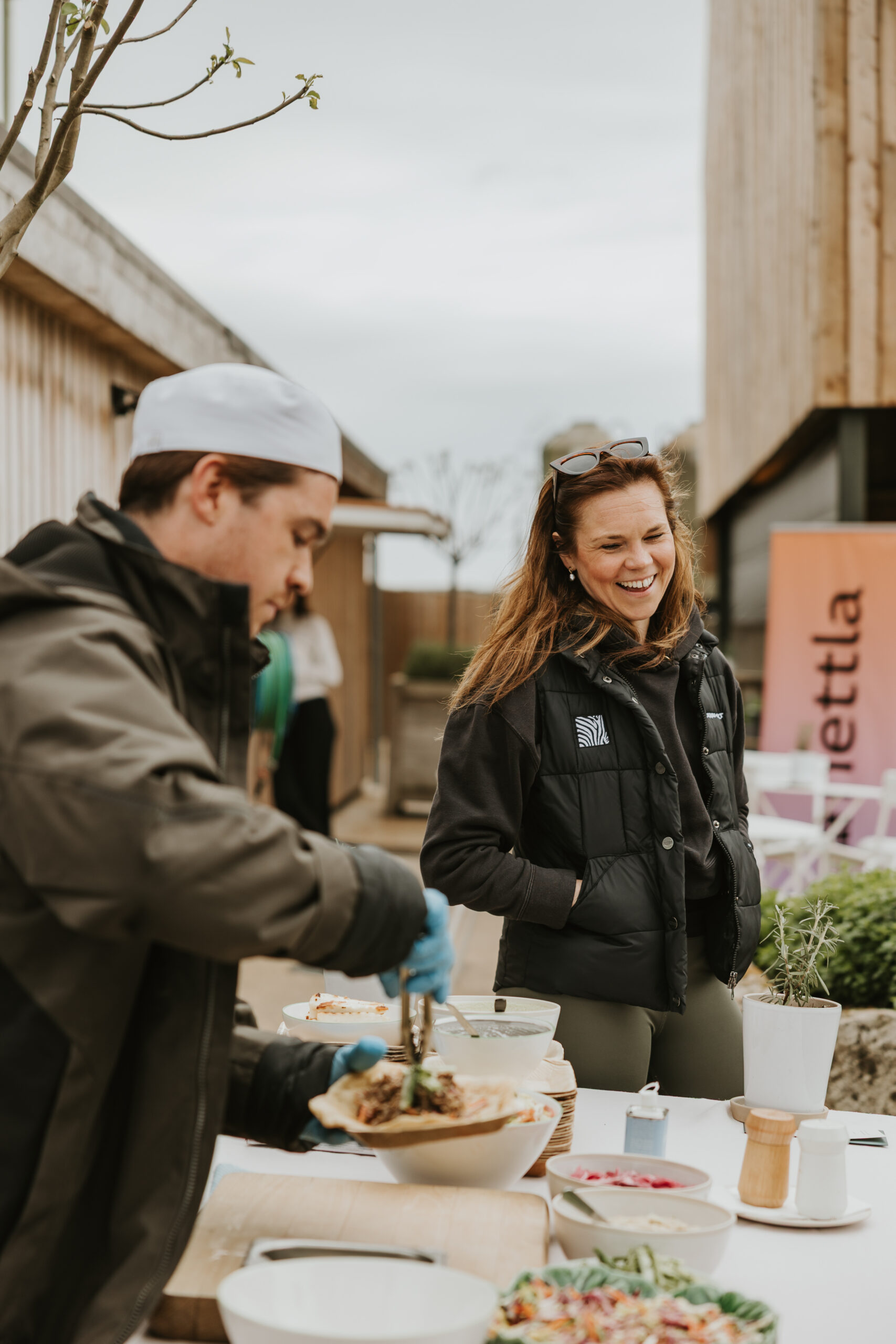 Woman smiling over the food being served at a business event at Daylesford Organic